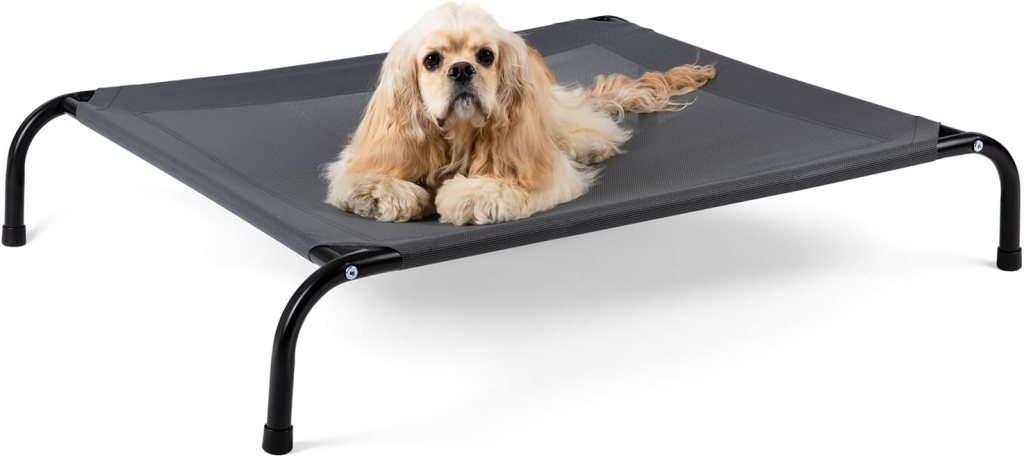 A medium-sized dog relaxing on a grey elevated dog bed with a breathable mesh surface and non-slip floor protectors.