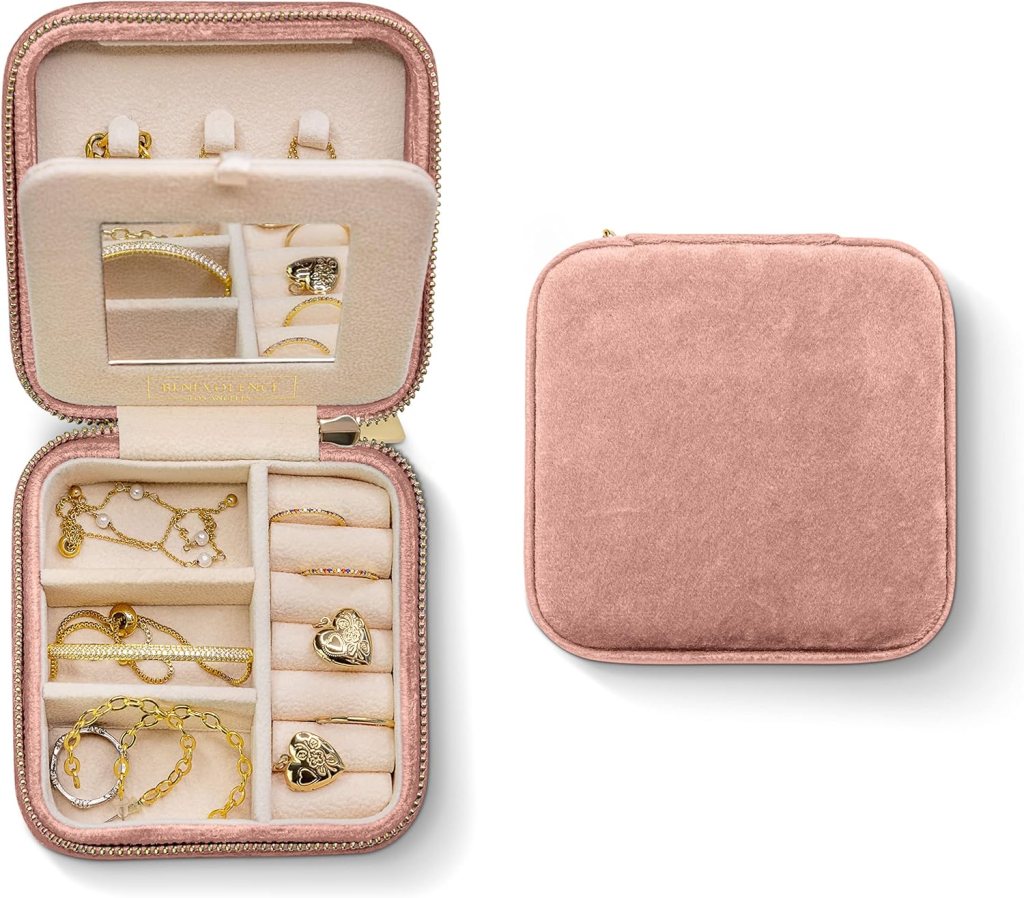 A dusty pink plush velvet jewelry box opened to show various pieces of jewelry organized inside, including necklaces and rings, next to a closed version of the box.